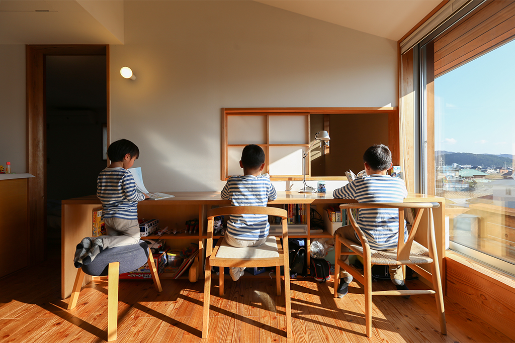 姫路市の木の家 フリースペースの勉強机に仲良く座る三兄弟