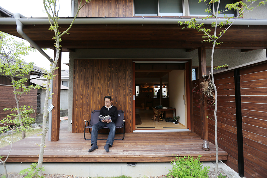 加古川市の木の家 デッキで読書をするご主人